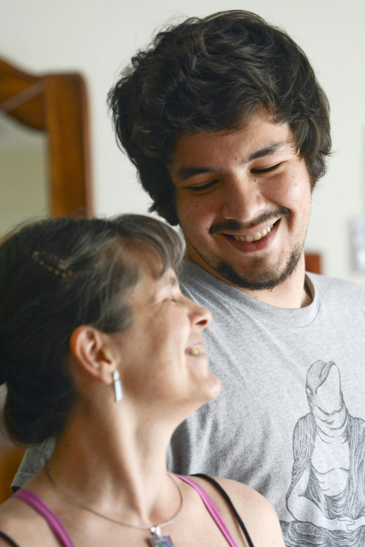 Claudia Castagliola, 45, laughs with her eldest son, Cristobal Gonzalez, 23, in her home’s living room. The two will graduate from a PhD program and a Master’s program, respectively, this week.