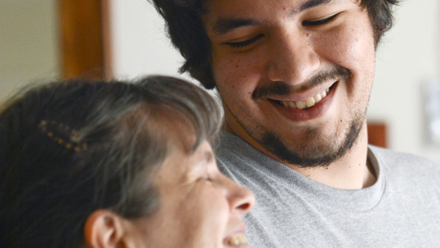 Claudia Castagliola, 45, laughs with her eldest son, Cristobal Gonzalez, 23, in her home’s living room. The two will graduate from a PhD program and a Master’s program, respectively, this week.
