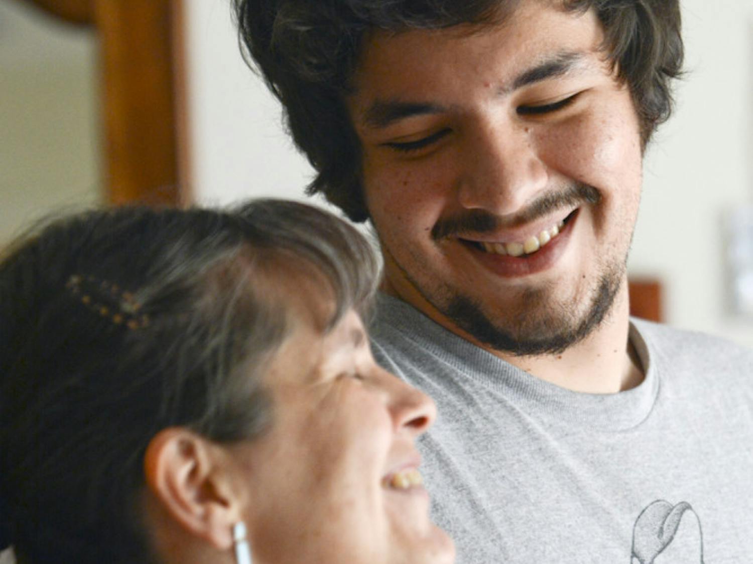 Claudia Castagliola, 45, laughs with her eldest son, Cristobal Gonzalez, 23, in her home’s living room. The two will graduate from a PhD program and a Master’s program, respectively, this week.