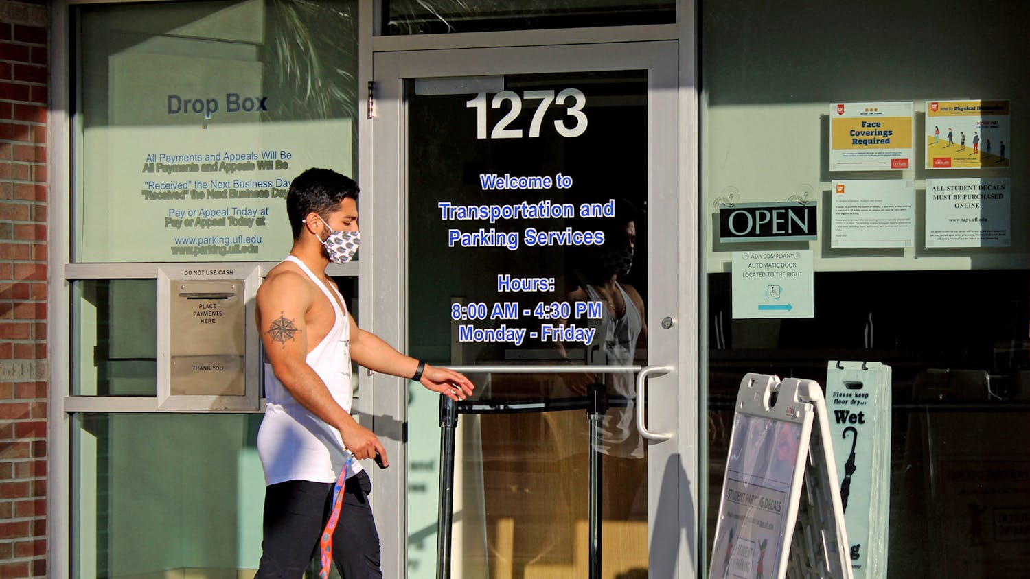 Julian Cruz, 20, applied physiology and kinesiology junior walks into the UF Transportation and Parking Services office on Thursday, Jan. 14, 2021. He was applying for a parking decal for the UF Health Shands Hospital parking lot.