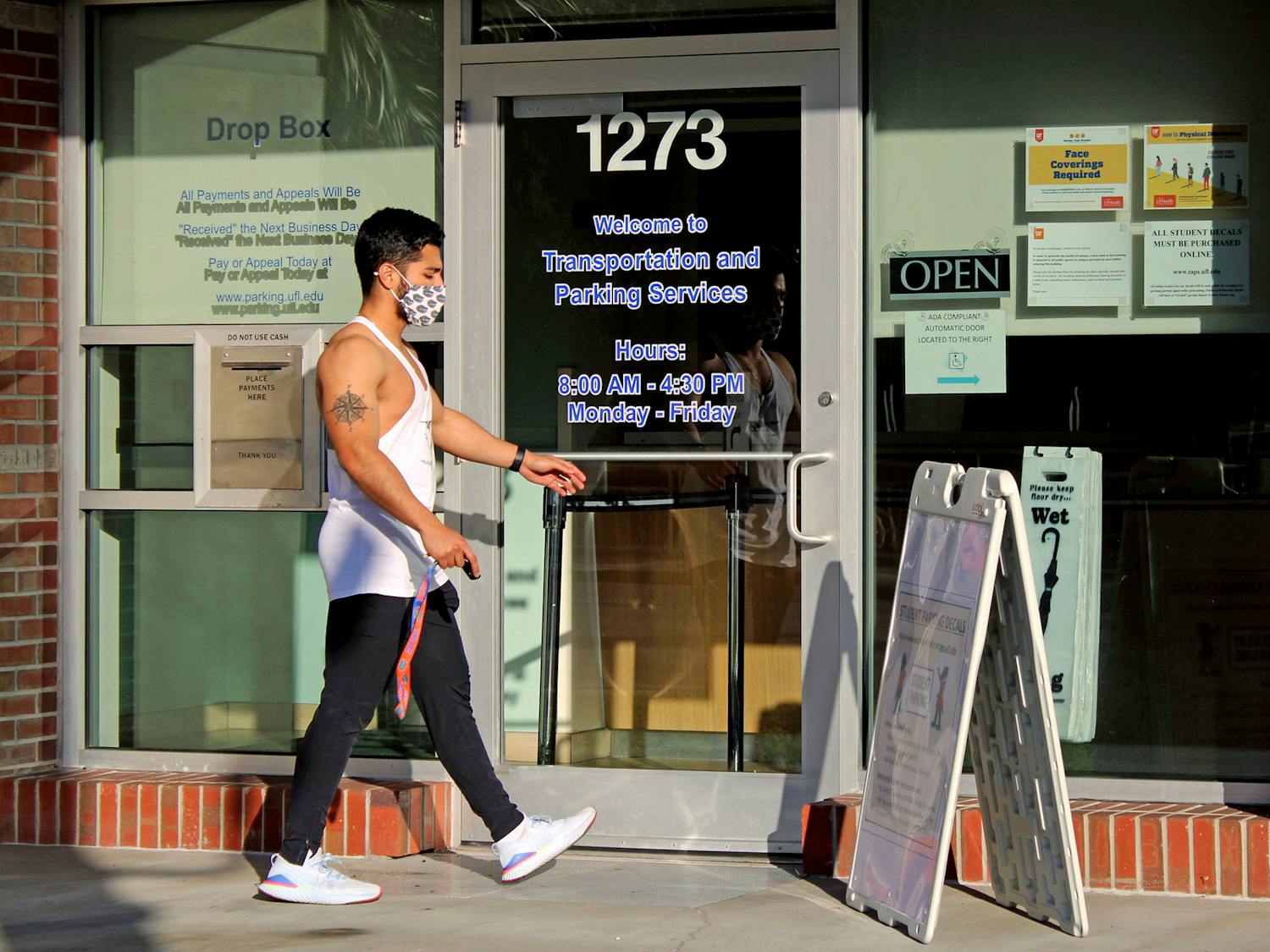 Julian Cruz, 20, applied physiology and kinesiology junior walks into the UF Transportation and Parking Services office on Thursday, Jan. 14, 2021. He was applying for a parking decal for the UF Health Shands Hospital parking lot.