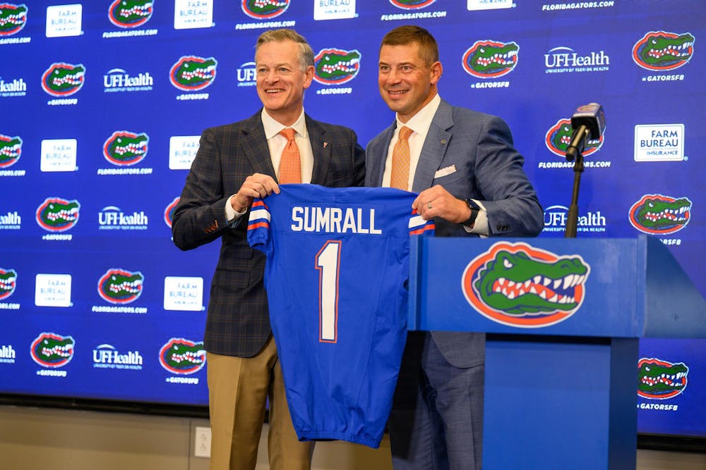 UF’s Athletics Director, Scott Stricklin, presents head coach Jon Sumrall with a jersey at his introductory press conference at Heavener Football Training Center in Gainesville, Fla., Monday, Dec. 1, 2025.