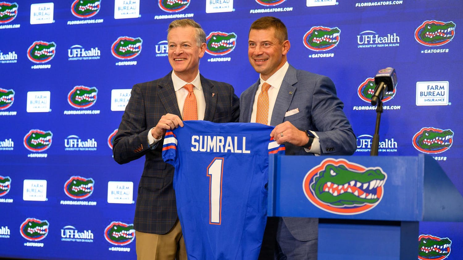 UF’s Athletics Director, Scott Stricklin, presents head coach Jon Sumrall with a jersey at his introductory press conference at Heavener Football Training Center in Gainesville, Fla., Monday, Dec. 1, 2025.