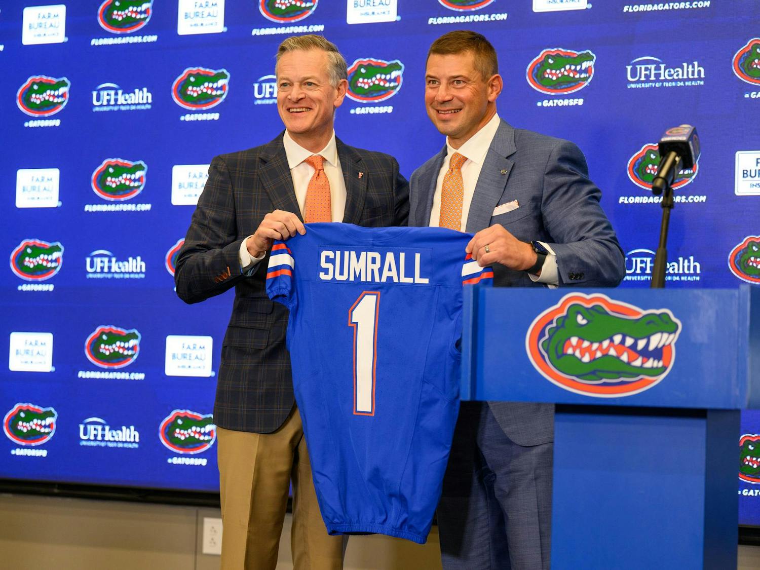 UF’s Athletics Director, Scott Stricklin, presents head coach Jon Sumrall with a jersey at his introductory press conference at Heavener Football Training Center in Gainesville, Fla., Monday, Dec. 1, 2025.