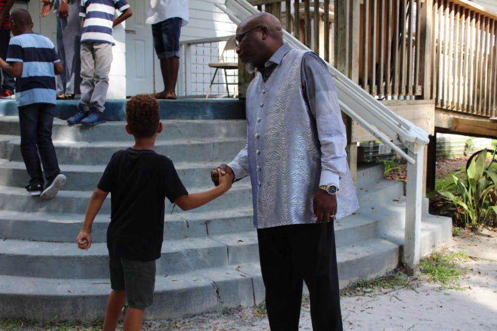 Chris Stokes greets a young churchgoer on Sunday outside the New Beginning Christian Worship Center in Micanopy. About 20 children attended the service.
