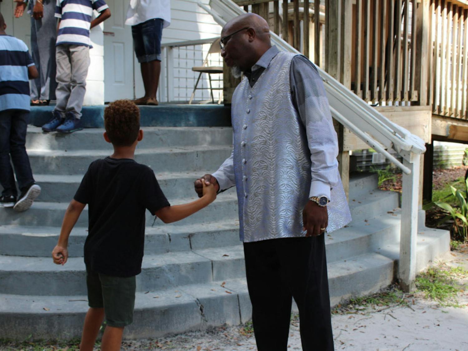 Chris Stokes greets a young churchgoer on Sunday outside the New Beginning Christian Worship Center in Micanopy. About 20 children attended the service.
