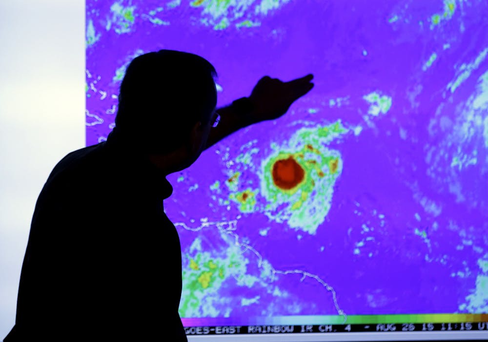 <p>James Franklin, chief hurricane forecaster, looks at an image of Tropical Storm Erika as it moves westward towards islands in the eastern Caribbean, at the National Hurricane Center, Wednesday, Aug. 26, 2015, in Miami.</p>