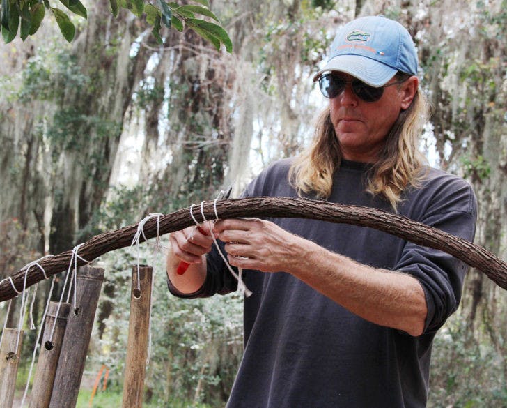 UF greenhouse manager Jeff Hubbard helps dismantle artist Jon Anderson’s “Bambooville” on Tuesday. The university requested Monday that the site be cleared within 72 hours.