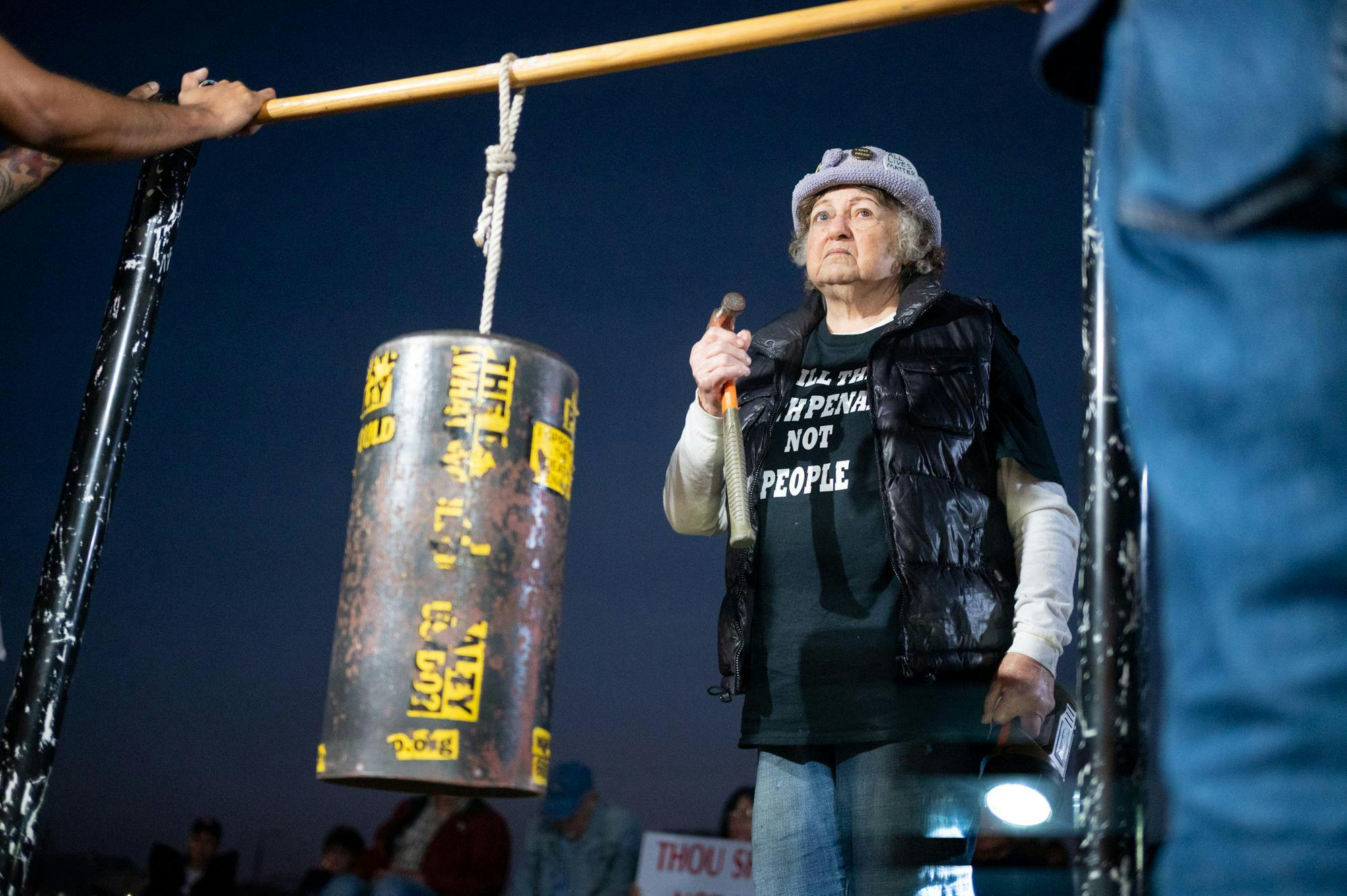Helen Pajama, protester in opposition of Bryan Frederick Jennings’ execution, bangs a hammer on a metal cylinder in solidarity. Jennings was executed in Raiford on Thursday, Nov. 13, 2025.