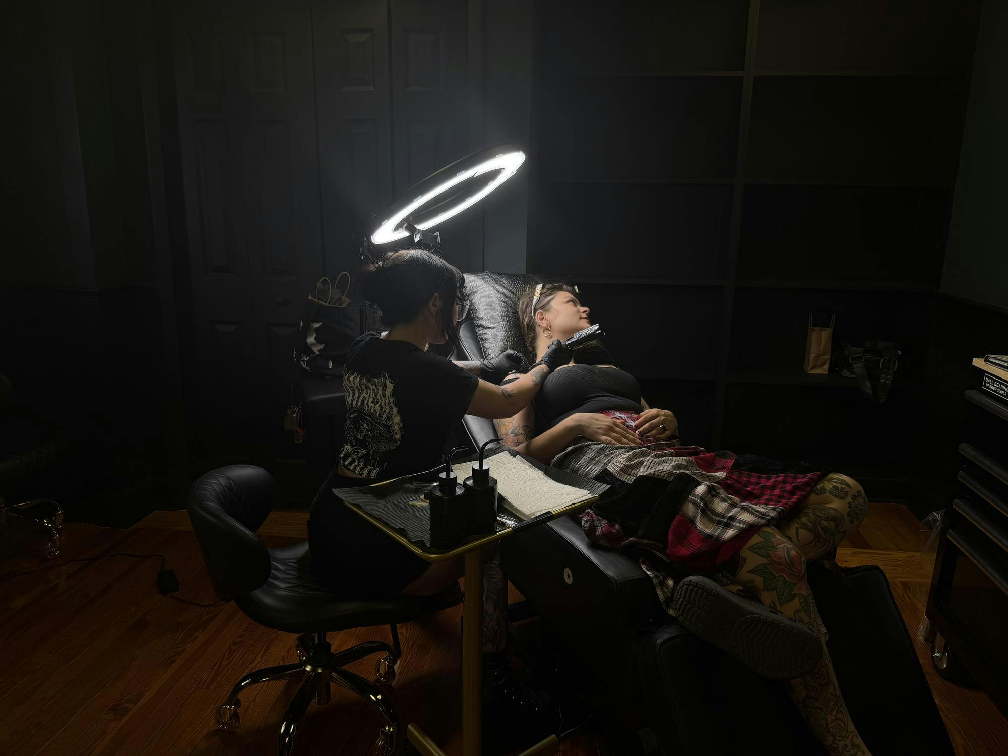 Tattoo artist Bibi Cascio draws a flower on Hannah Barbakoff's collarbone at Emerald Scarab Tattoo Parlor in Gainesville, Fla. 