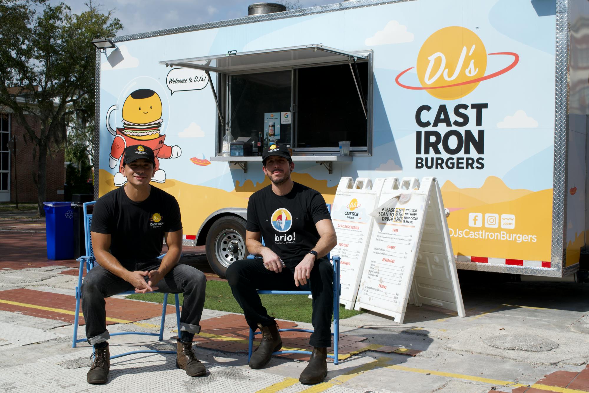 José Nieves and Miguel Cardona sit in front of their food truck in Gainesville.