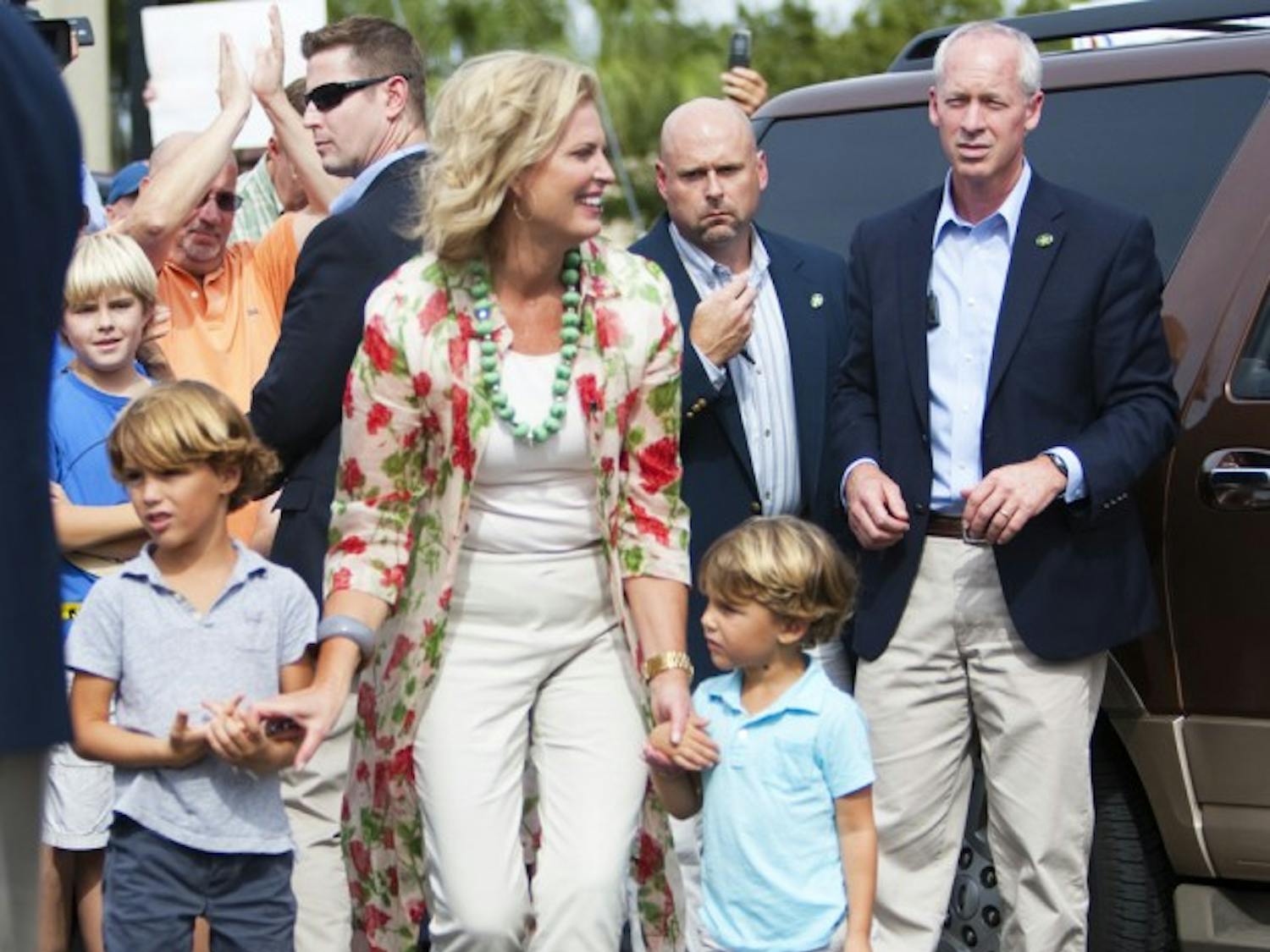 Ann Romney walks with two of her grandchildren after greeting supporters at David’s Real Pit BBQ located on Northeast 23rd Avenue on Thursday afternoon.