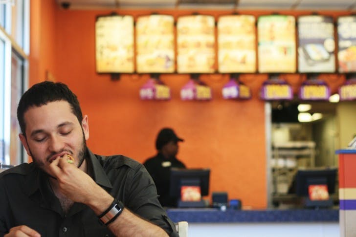 Alex Cardelle, 22-year-old political science and economics senior, eats lunch at Taco Bell. Taco Bell's new breakfast menu is not yet available in Florida.