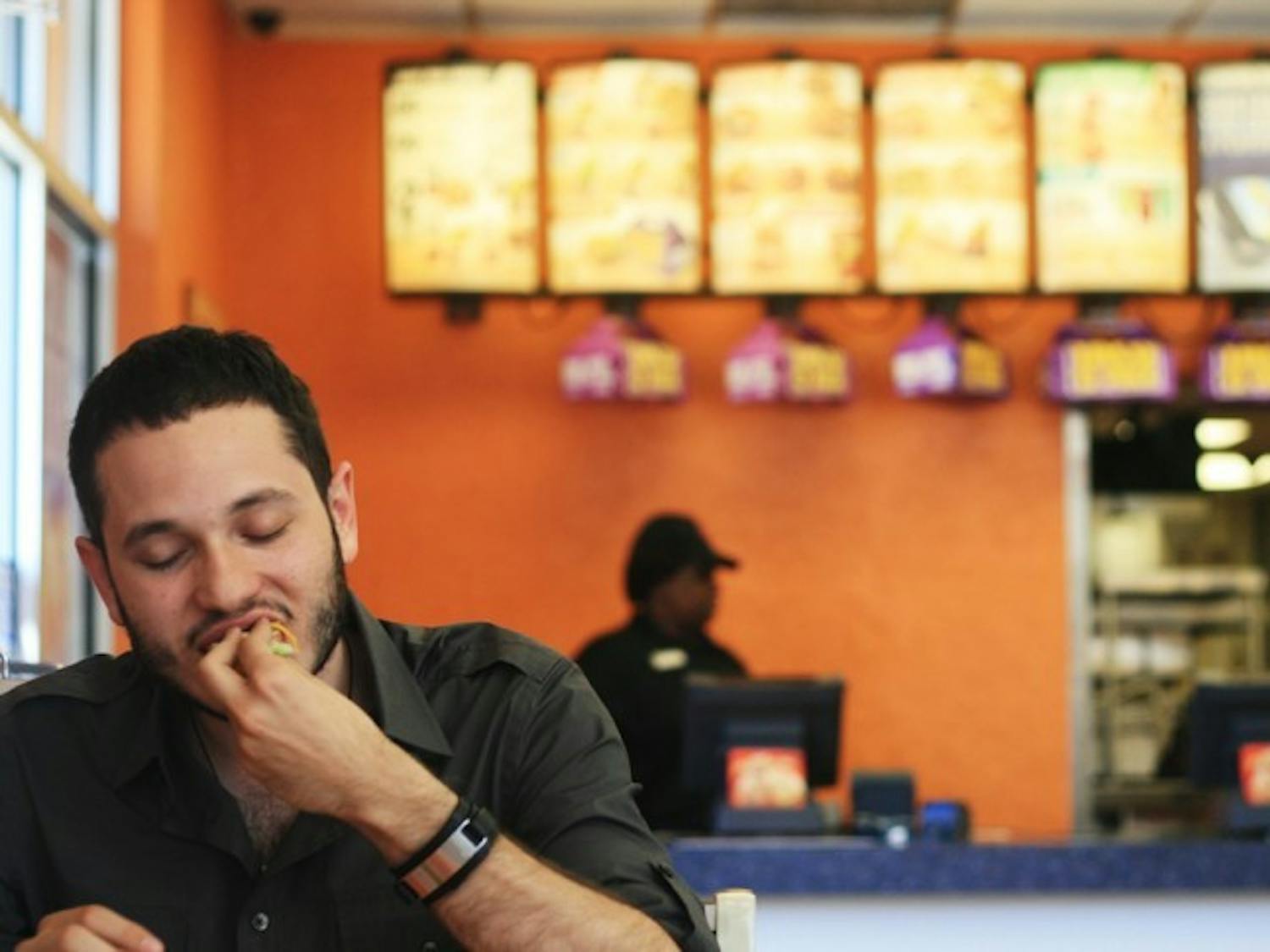 Alex Cardelle, 22-year-old political science and economics senior, eats lunch at Taco Bell. Taco Bell's new breakfast menu is not yet available in Florida.