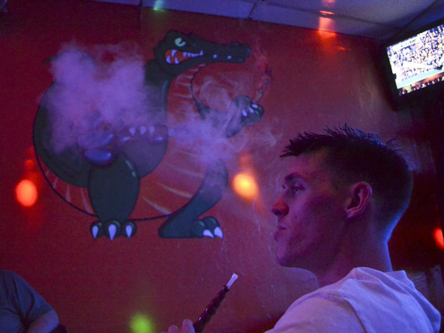 Taylor Ratcliff, a 23-year-old who will return to UF as a history senior in the spring, blows out Gator Mist flavored smoke at Sheesha on Oct. 7, 2015. Ratcliff said he used smoke at Sheesha twice a week with friends, but hadn’t been back in a while because he purchased his own hookah.