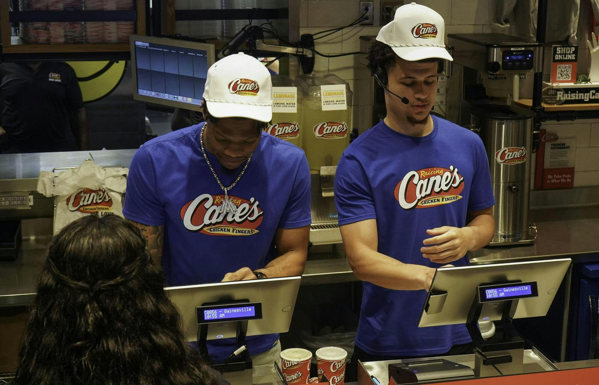 Alijah Martin and Walter Clayton Jr. take orders at Raising Cane's on W University Ave on Thursday, April 10, 2025