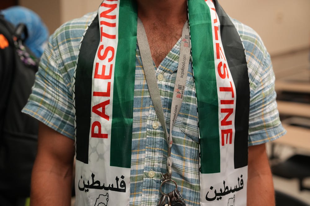 An attendee of UF SJP’s discussion in Turlington wearing a Palestine keffiyeh neck scarf on Thursday Oct. 12, 2023. 