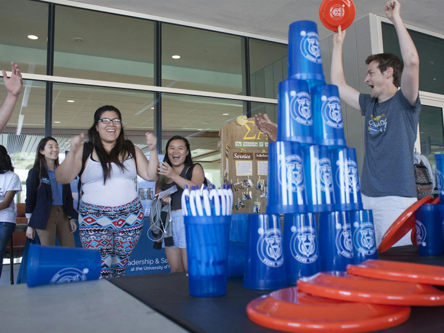 Julisia Hernandez, a 21-year-old mechanical engineering senior, celebrates after winning a flying disc that Kyle Eastman, a 29-year-old alumnus, holds at Alpha Omega Campus Ministry’s booth at the the Spring Student Org Fair on Wednesday. “Anybody can come join,” Eastman said about the ministry.