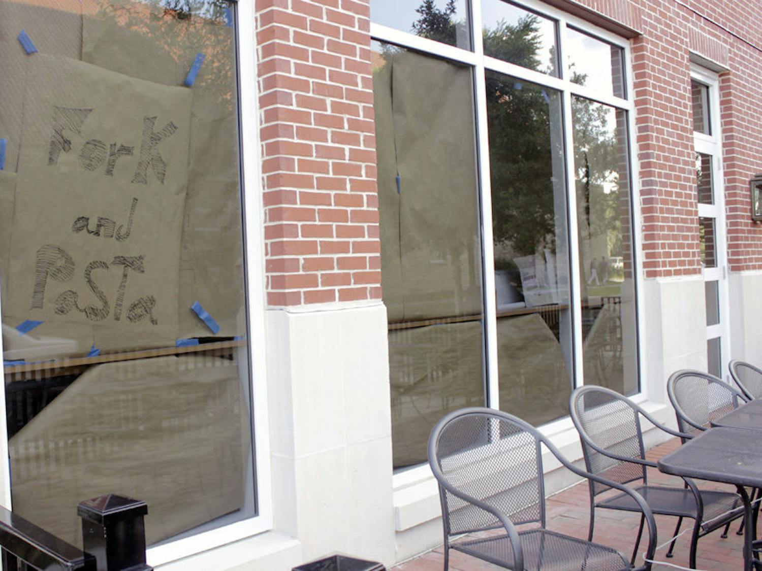 A paper sign hangs in the window of Fork and Pasta at 1802 W University Ave. on Wednesday.