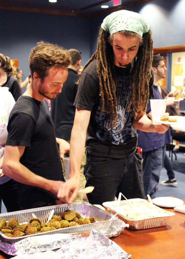 Jonathan Church, 21, a Burrito Brothers Taco Co. employee, and Simon Nash, 20, a Santa Fe philosophy and political science junior, pick falafel and hummus to sample.