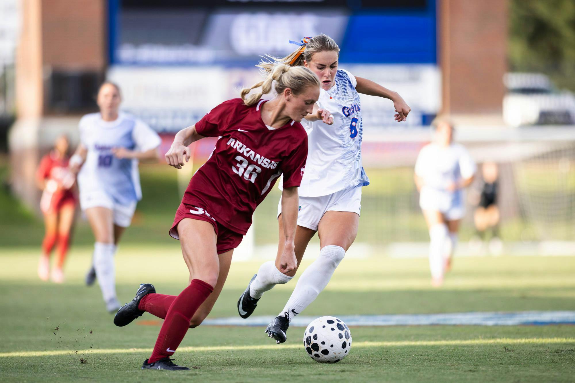 Charlotte McClure (8) dribbles past an Arkansas defender during the Gators’ match at Donald R. Dizney Stadium in Gainesville on Wednesday, Sept. 10, 2025.