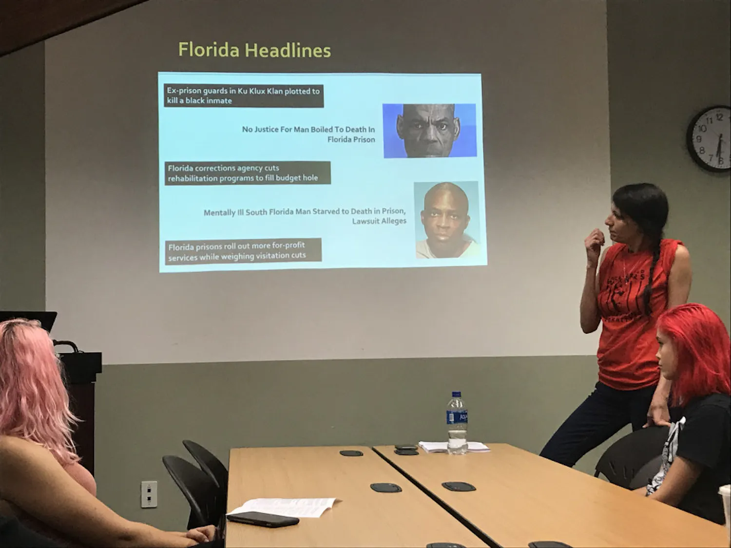 Representatives from Gainesville Incarcerated Workers Organizing Committee and Fight Toxic Prisons listen while an inmate speaks over the phone.