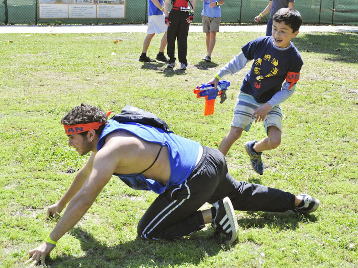 Nick Mullen, 12, chucks a sock at a zombie during a Humans vs. Zombies mini-mission for Children's Miracle Network Hospitals on the North Lawn on Saturday. Mullen was born with hypertrophic cardiomyopathy and has been treated at UF Health Children’s Hospital, where his mother, Jodi, is a pediatric nurse.