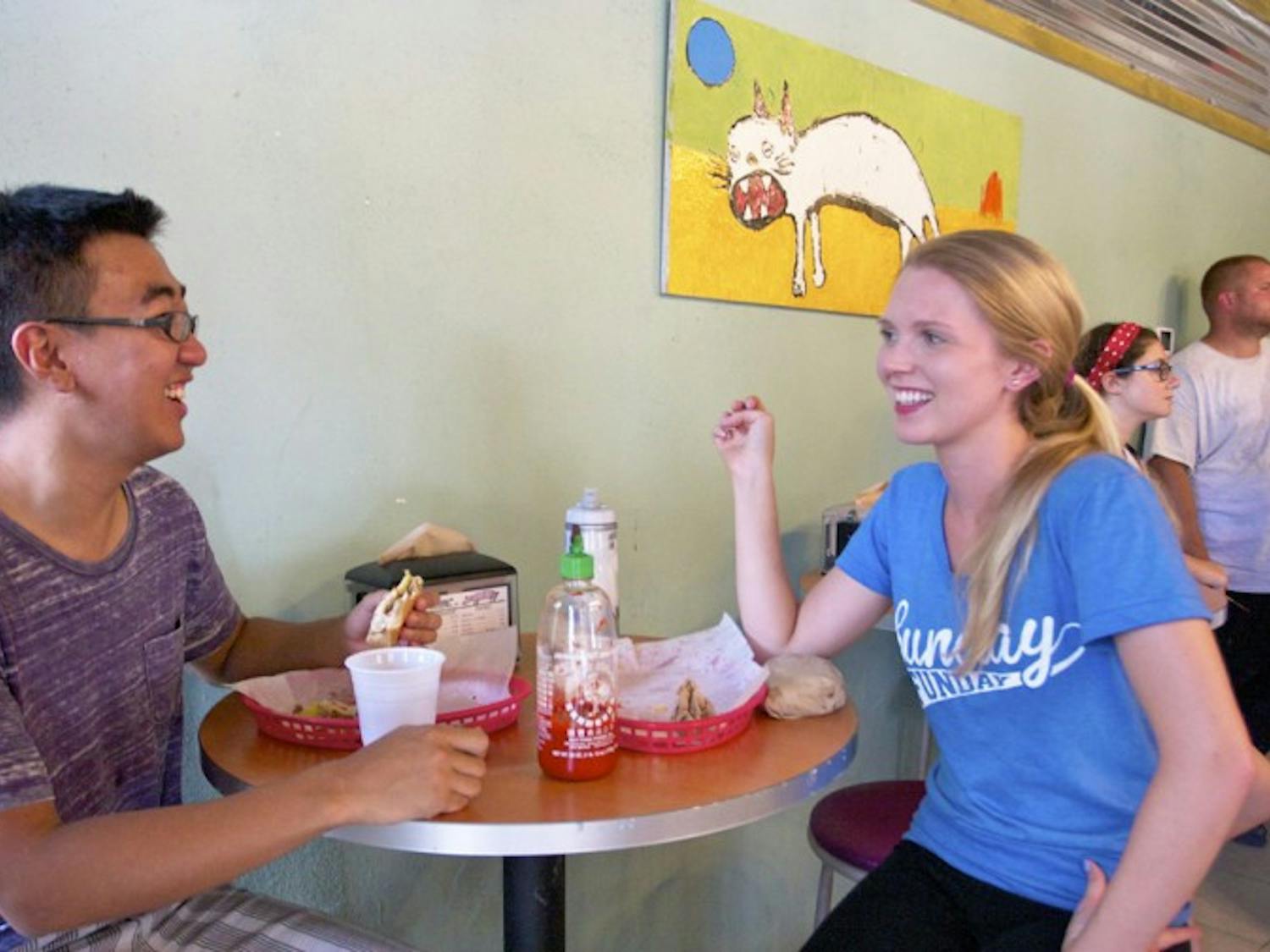 Weizhi Cheng, 22, enjoys a Cuban gator sandwich during lunch with Heather Rivers, 22, at the Midtown Flaco’s Cuban Bakery on Wednesday afternoon.