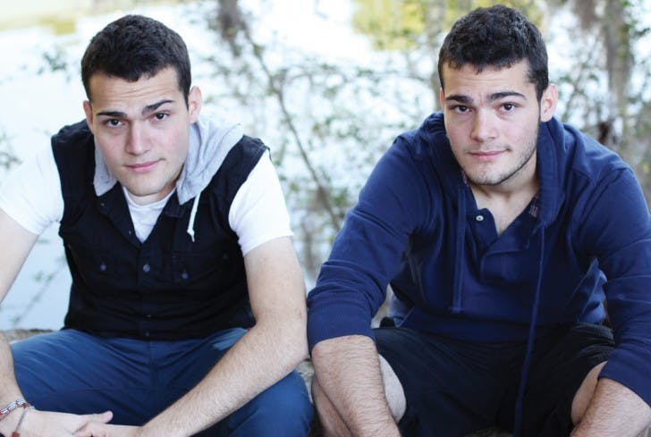Garit twins Luis, left, and Jorge, right, sit on a bench south of Marston Science Library. The brothers, originally from Cuba, together lost 200 pounds in a little less than a year.