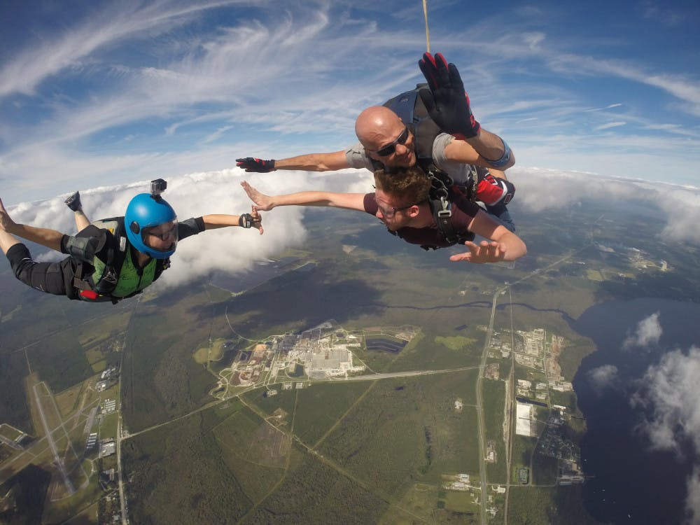 UF senior public relations student Taylor Thelander, 21, gives UF business management senior Ryan Walsh, 21, a high-five on his first tandem skydiving jump in the air above Kay Larkin Airport in Palatka, Florida. The two took part in a UF Falling Gators Skydiving Club event with Skydive Palatka on Saturday.