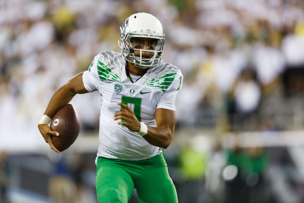 Oregon quarterback Marcus Mariota runs the football during the second quarter of an NCAA college football game against South Dakota in Eugene, Ore., Saturday, Aug. 30, 2014.
