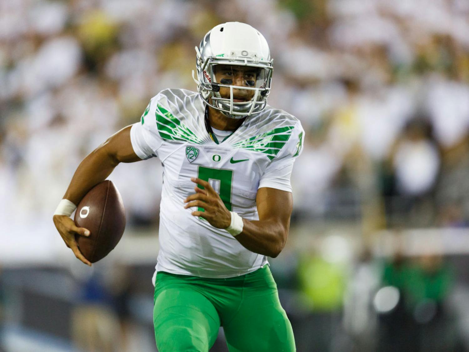 Oregon quarterback Marcus Mariota runs the football during the second quarter of an NCAA college football game against South Dakota in Eugene, Ore., Saturday, Aug. 30, 2014.