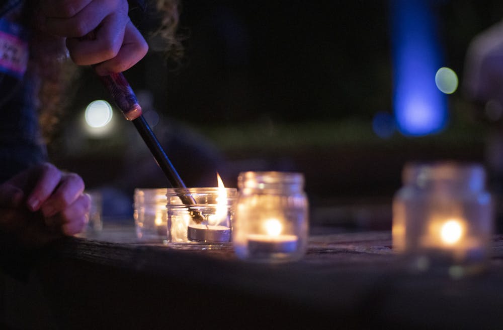 Karina A., TranQuility volunteer, lights a candle during a vigil for Transgender Day of Remembrance at Bo Diddley Plaza on Saturday, Nov. 20, 2021.