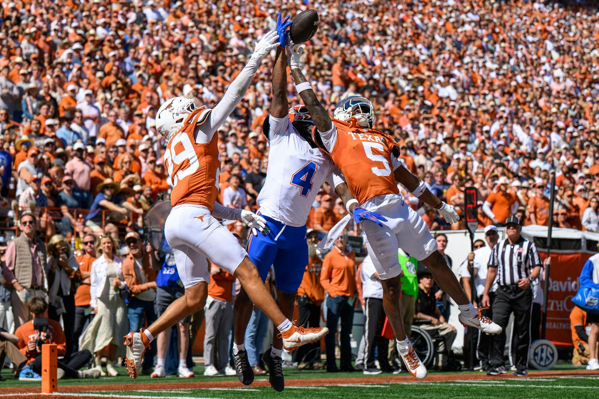 Florida wide receiver TJ Abrams (4) jumps for a ball defended by Texas defensive back Graceson Littleton (29) and defensive back Bo Mascoe (5) during the second half of an NCAA college football game, Saturday, Oct. 17, 2026, in Austin, Texas.