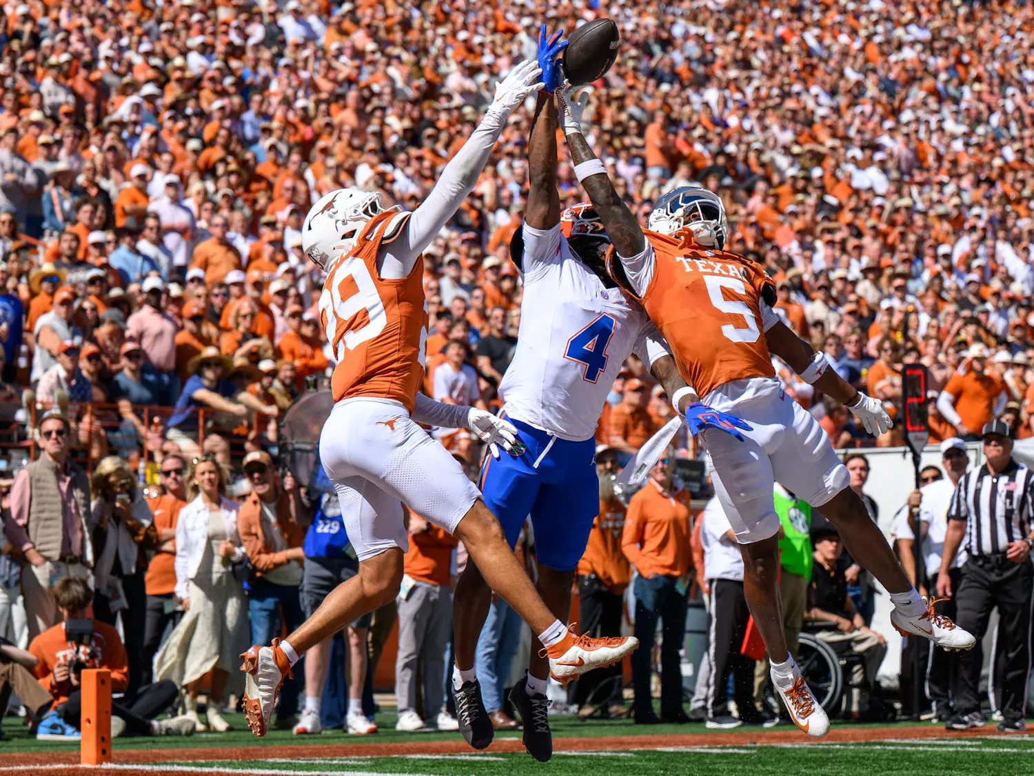 Florida wide receiver TJ Abrams (4) jumps for a ball defended by Texas defensive back Graceson Littleton (29) and defensive back Bo Mascoe (5) during the second half of an NCAA college football game, Saturday, Oct. 17, 2026, in Austin, Texas.