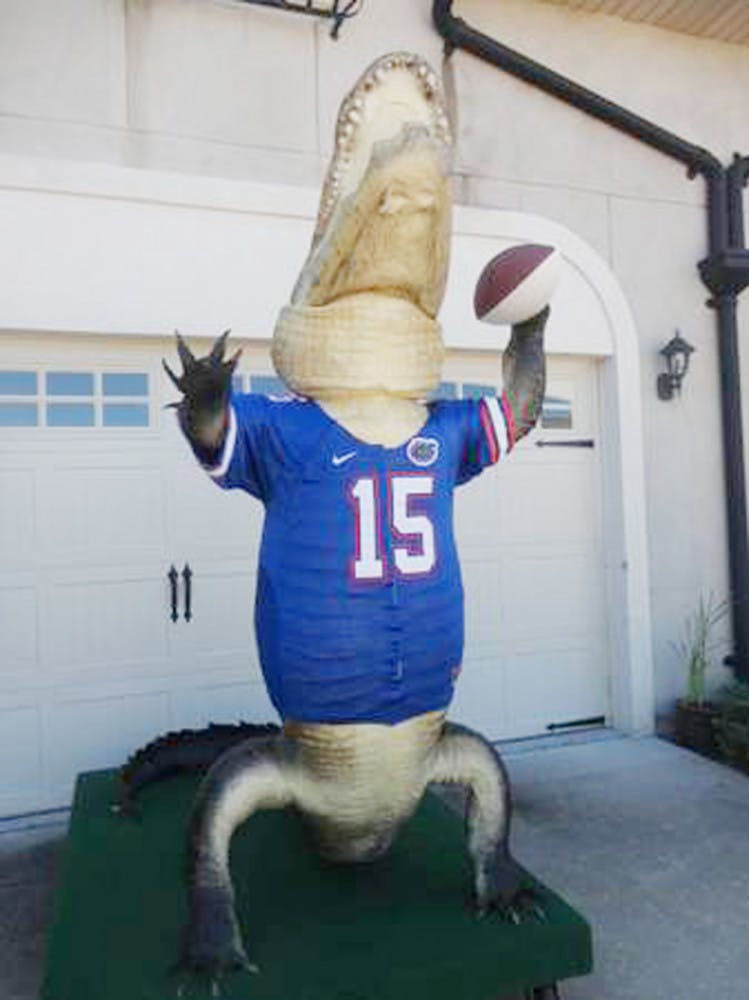 A 13-foot-4-inch bull alligator is mounted in the Heisman Trophy pose. He holds a football signed by Tim Tebow, Steve Spurrier and Danny Wuerffel.
