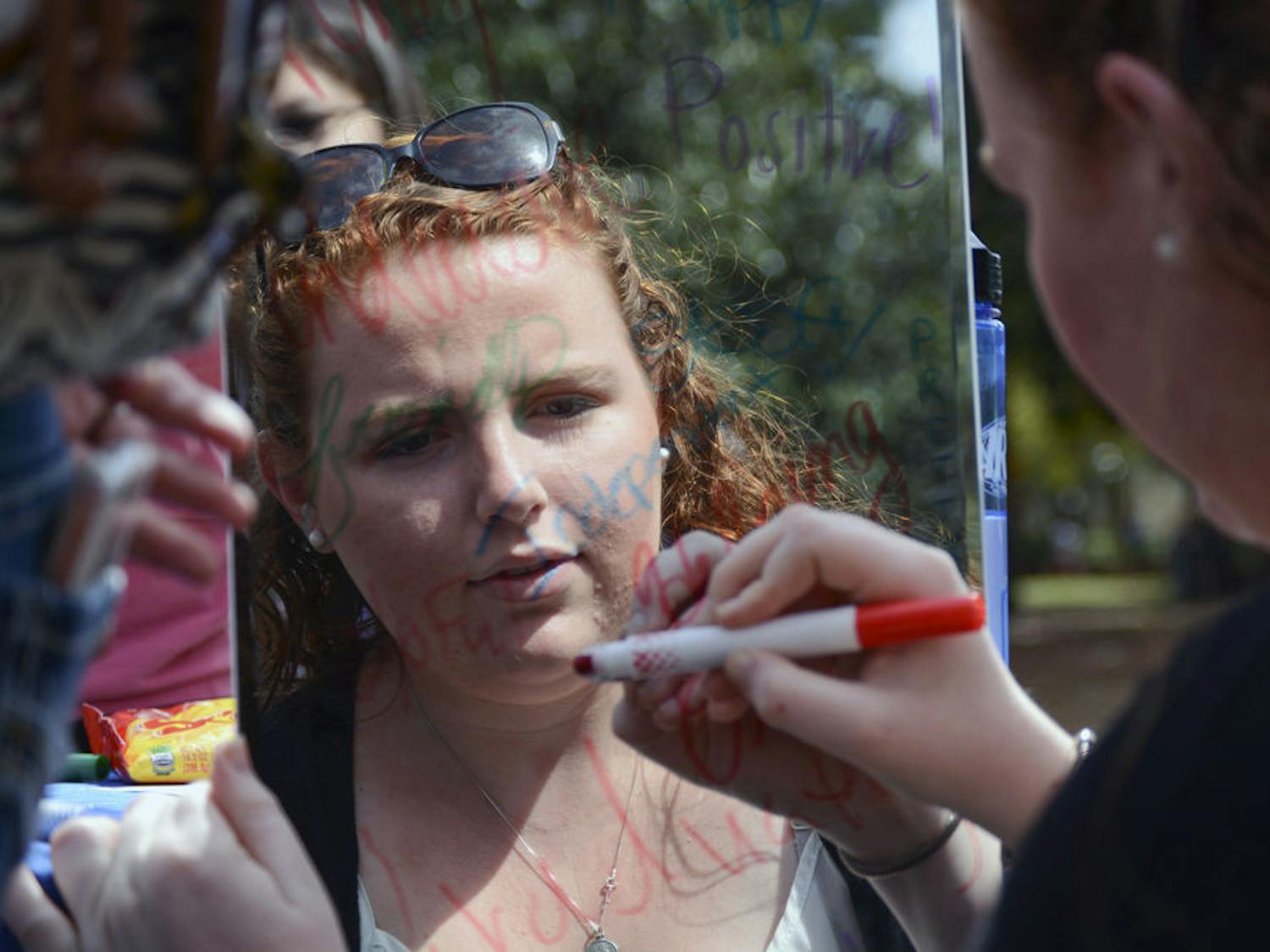 Niamh Clancy, an 18-year-old UF biology freshman, writes on a mirror on Plaza of the Americas as part of the “Mirrorless Monday” event, which was sponsored by GatorWell and partnered with Housing and Residence Education, the Student Health Care Center and RecSports. They invited students to write things they liked about themselves on mirrors around campus. Clancy wrote, “I like to make others happy.”