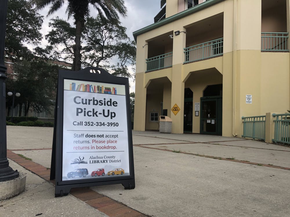 Signs outside of the Headquarters Branch of the Alachua County Library District direct patrons interested in curbside service.