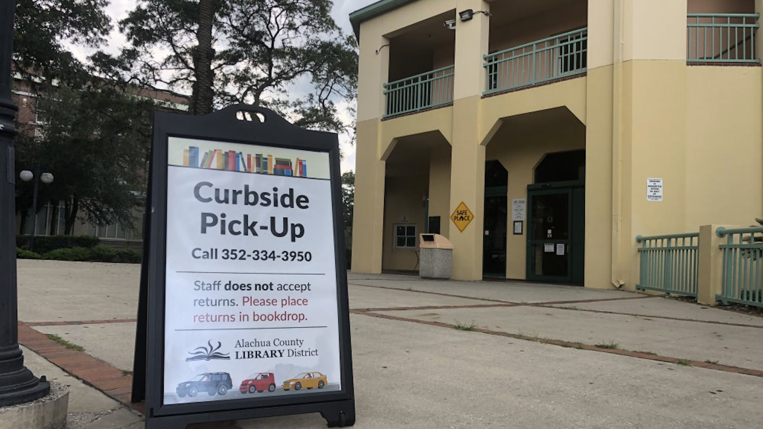 Signs outside of the Headquarters Branch of the Alachua County Library District direct patrons interested in curbside service.