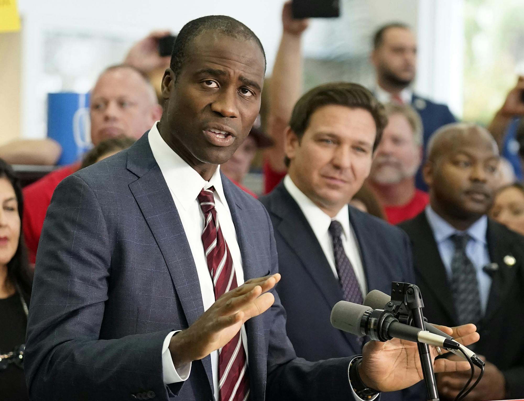 Florida Surgeon General Dr. Joseph Ladapo, front left, gestures as he speaks to supporters and members of the media before a bill signing by Gov. Ron DeSantis, front right, Nov. 18, 2021, in Brandon, Fla. (AP Photo/Chris O&#x27;Meara, File)