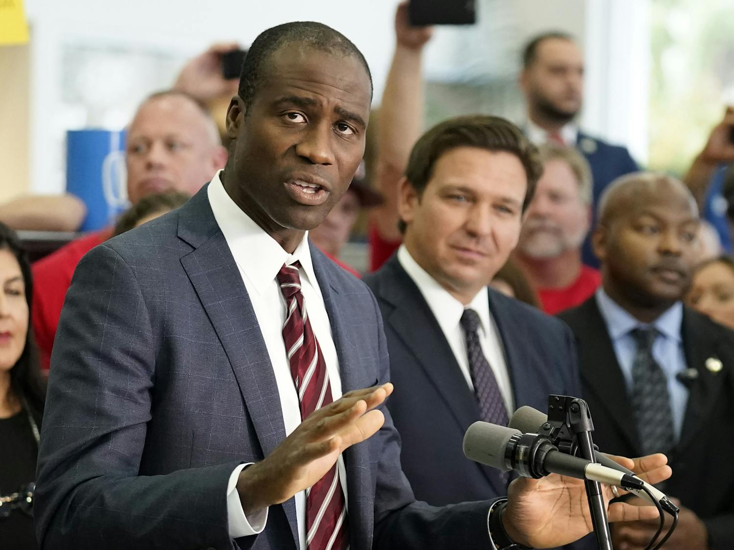 Florida Surgeon General Dr. Joseph Ladapo, front left, gestures as he speaks to supporters and members of the media before a bill signing by Gov. Ron DeSantis, front right, Nov. 18, 2021, in Brandon, Fla. (AP Photo/Chris O'Meara, File)