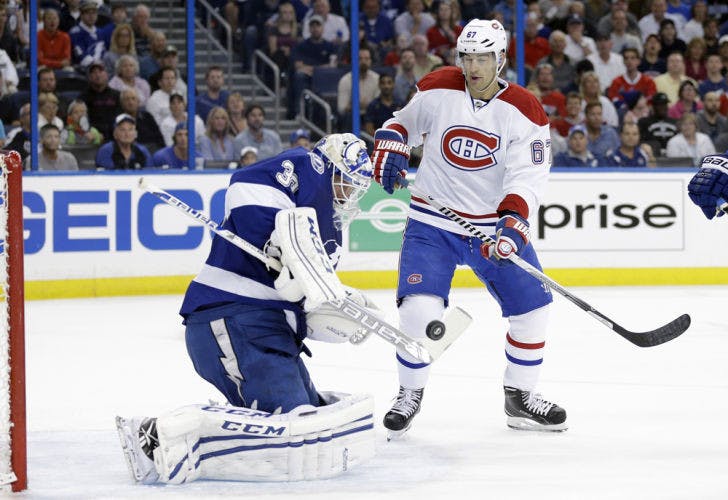 Tampa Bay goalie Anders Lindback (39) makes a save as Montreal winger Max Pacioretty (67) looks for a rebound during Game 1 of their first-round playoff series in Tampa.