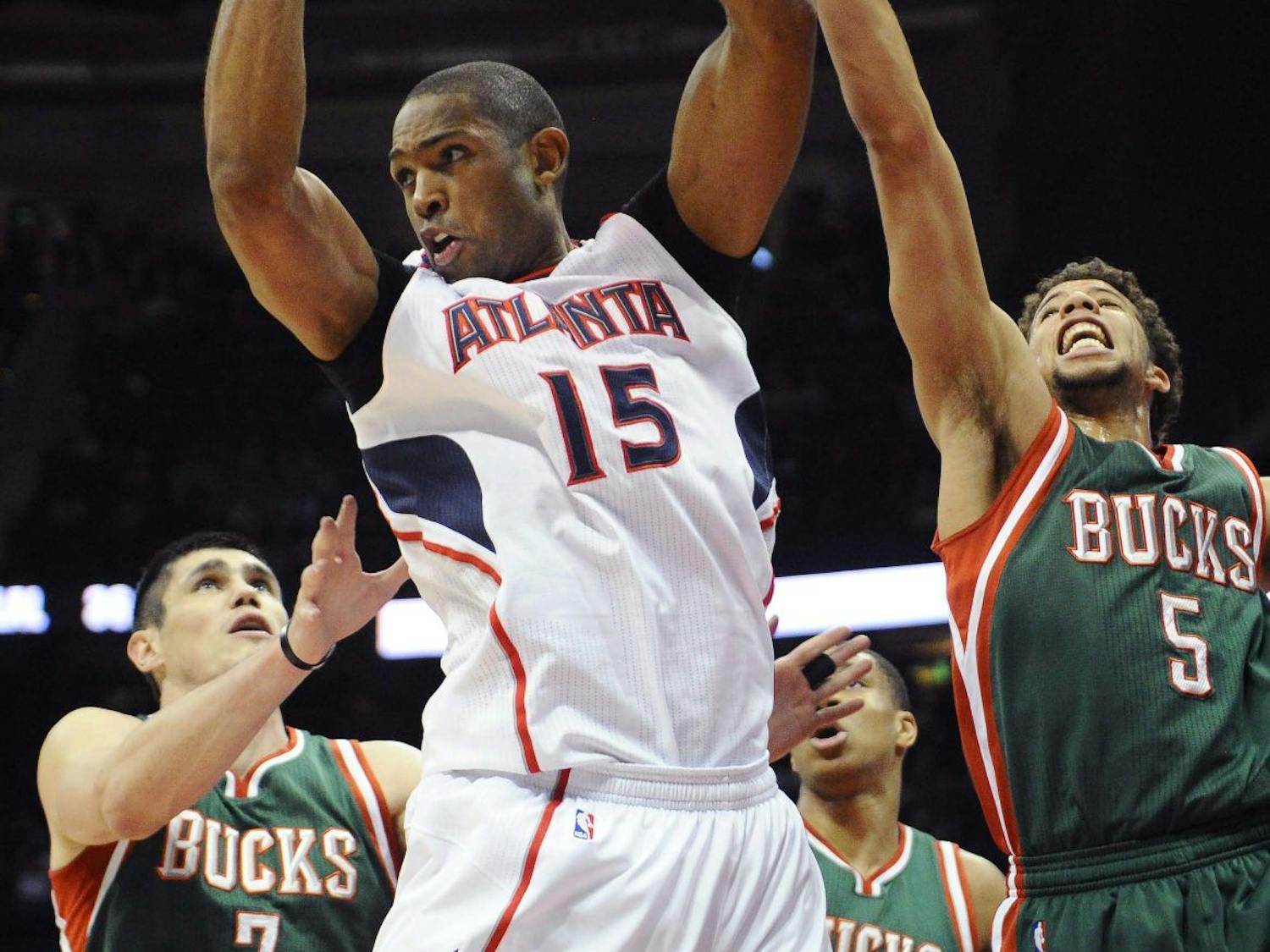 Atlanta Hawks' Al Horford (15) pulls down a rebound over Milwaukee Bucks' Ersan Ilyasova (7) and Michael Carter-Williams (5) in the first half of an NBA basketball game Monday, March 30, 2015, in Atlanta.