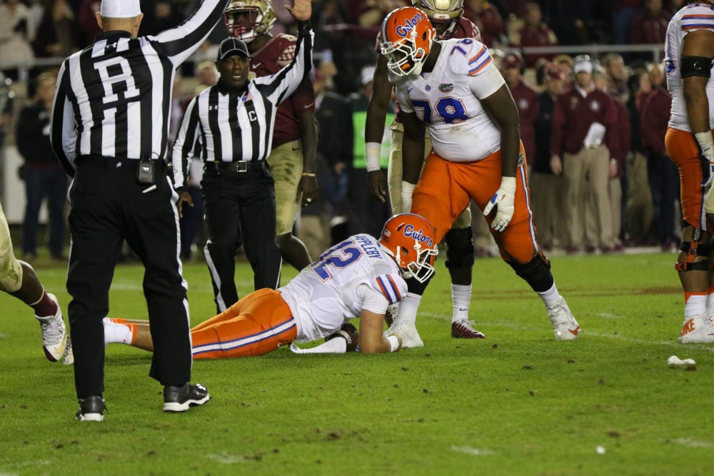 <p>Offensive lineman David Sharpe, right, stands over quarterback Austin Appleby during Florida's loss to Florida State on Nov. 26, 2016, in Tallahassee.</p>