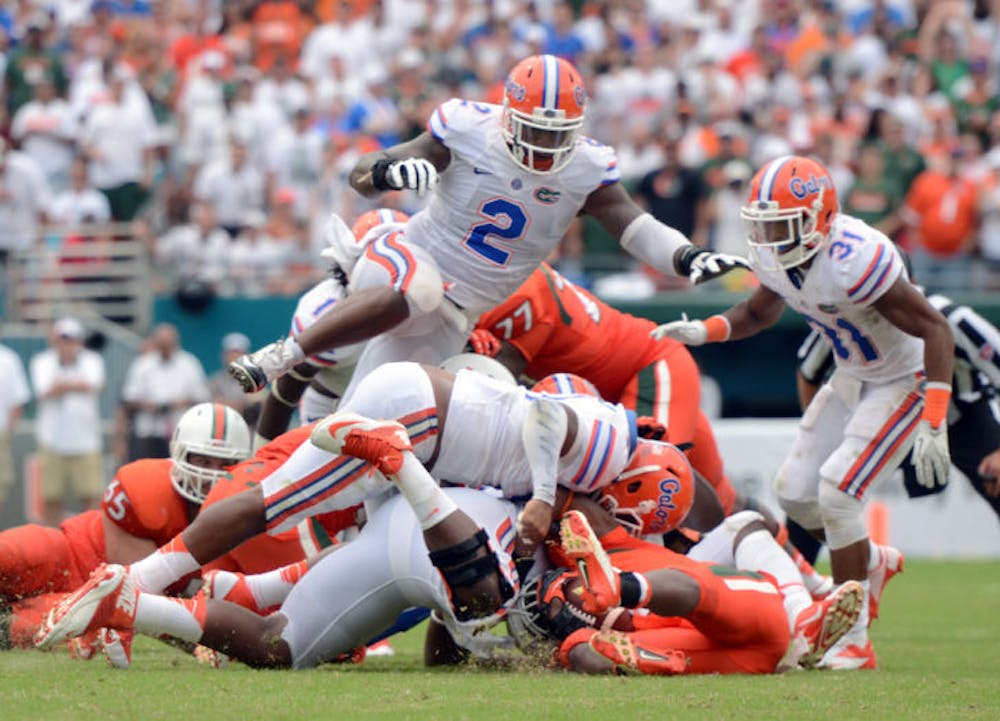 <p>Dominique Easley (2) leaps over a pile of players during Florida’s 21-16 loss to Miami on Sept. 7 in Sun Life Stadium. Florida’s defense is No. 3 in the nation, allowing 208.5 yards per game.</p>