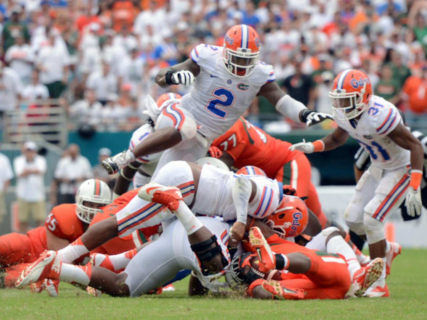Dominique Easley (2) leaps over a pile of players during Florida’s 21-16 loss to Miami on Sept. 7 in Sun Life Stadium. Florida’s defense is No. 3 in the nation, allowing 208.5 yards per game.