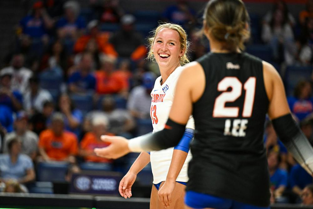 Florida Gators libero/defensive specialist Lily Hayes (13) shares a laugh with libero/defensive specialist Bella Lee (21) in a volleyball match against PVK Olymp Praha of the Czech Republic, on Tuesday, Aug. 26, 2025, at the O'Connell Center in Gainesville, Fla.