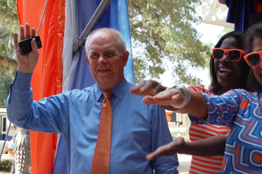<p>UF President Bernie Machen waves to Gators during the BEAT LSU T-Shirt Giveaway at Emerson Hall on the morning of Oct. 5. Among other guest speakers, Machen spoke to students about the Florida Opportunity Scholars Program.</p>