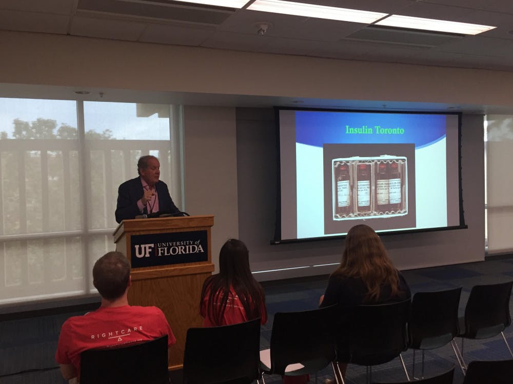 <p>Dr. Mark Atkinson presents a PowerPoint at Tuesday's forum in the Reitz Union.</p>