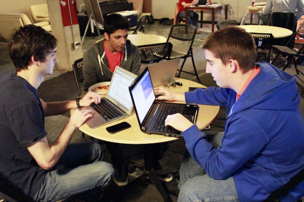 <p>Joe Furlott, 20, Shyamal Patel, 21, and Derek Brown, 21, a group of UF computer sciences juniors work on an Android application during Hackathon, a 24-hour event at Hackerspace on Saturday. Participants worked for a shot to win $500.</p>